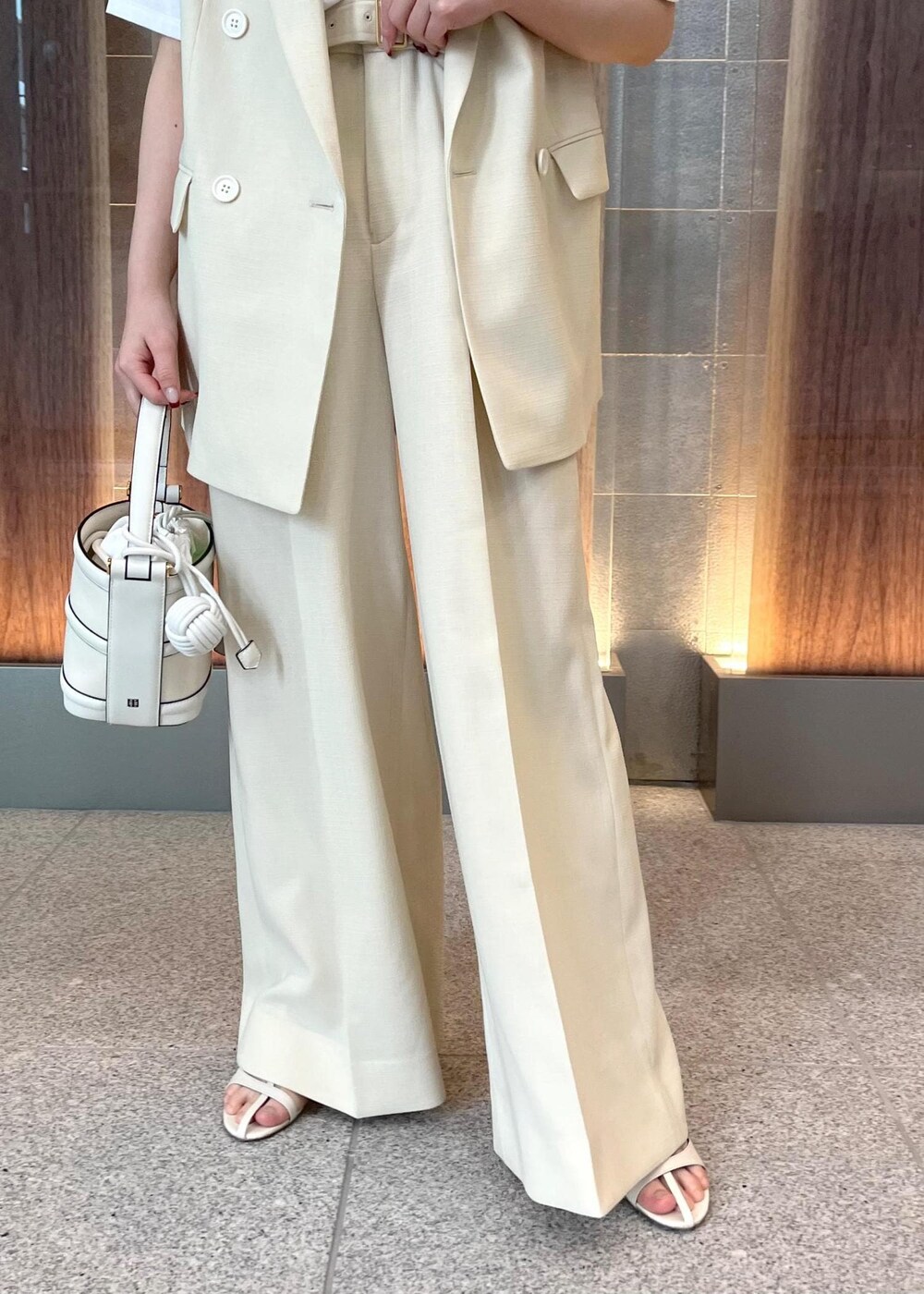 ホワイト系のハンドバッグ、ホワイト系のサンダル、ホワイト系のTシャツ/カットソーを着用したレディースの春コーディネートの8枚目の写真