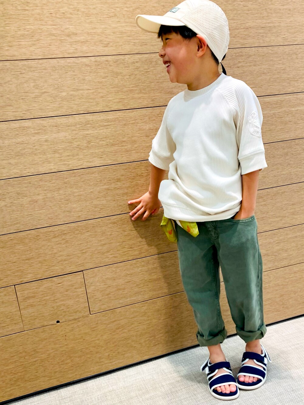 ベージュ系のTシャツ/カットソー、グリーン系のデニムパンツ、ブルー系のサンダルを着用したキッズの春コーディネートの2枚目の写真