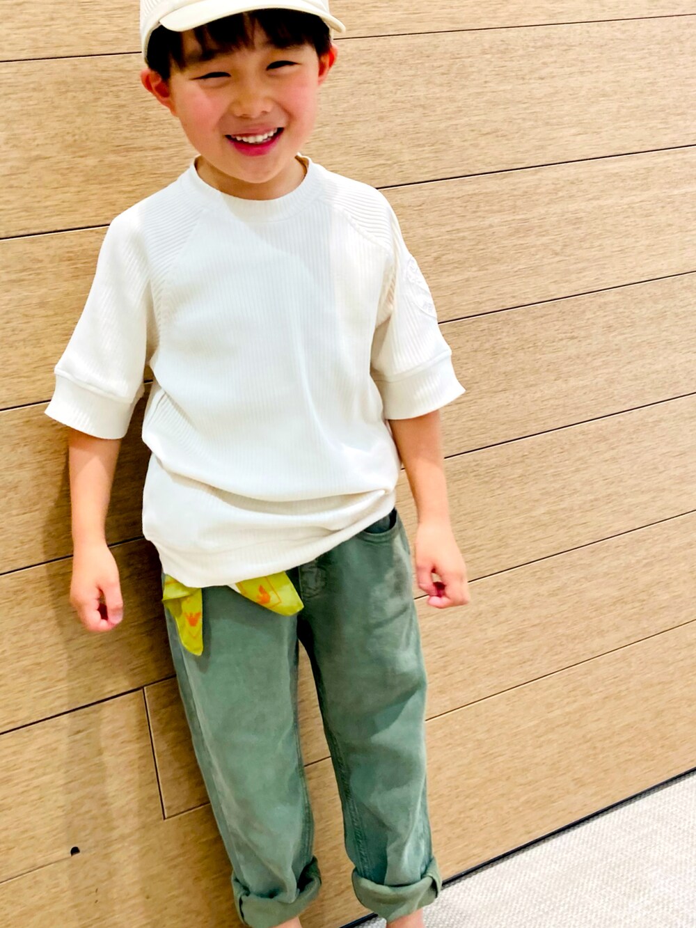 ベージュ系のTシャツ/カットソー、グリーン系のデニムパンツ、ブルー系のサンダルを着用したキッズの春コーディネートの3枚目の写真