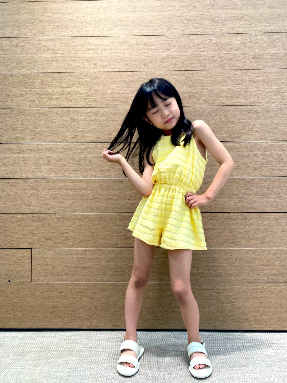 ホワイト系のサンダル、イエロー系のオールインワン・サロペットを着用したキッズの春コーディネートの3枚目の写真