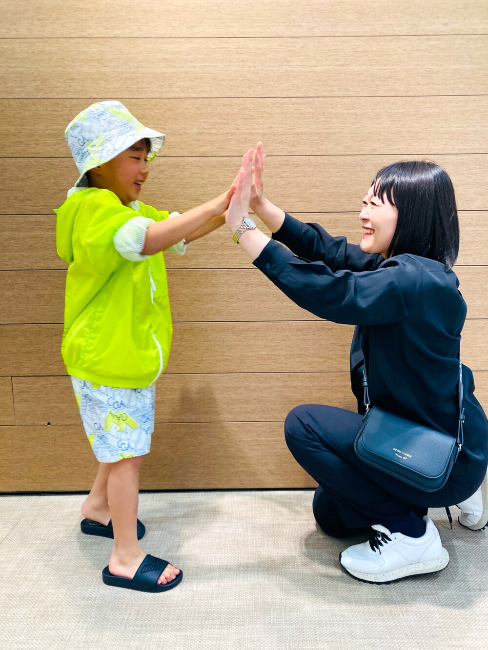 イエロー系のブルゾン、ホワイト系のスウェットパンツ、ホワイト系のハットを着用したキッズの春コーディネートの5枚目の写真