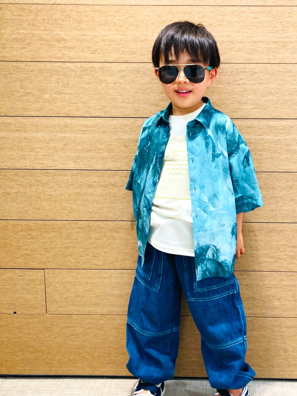 グリーン系のシャツ/ブラウス、ホワイト系のTシャツ/カットソー、ブルー系のデニムパンツを着用したキッズの春コーディネートの2枚目の写真