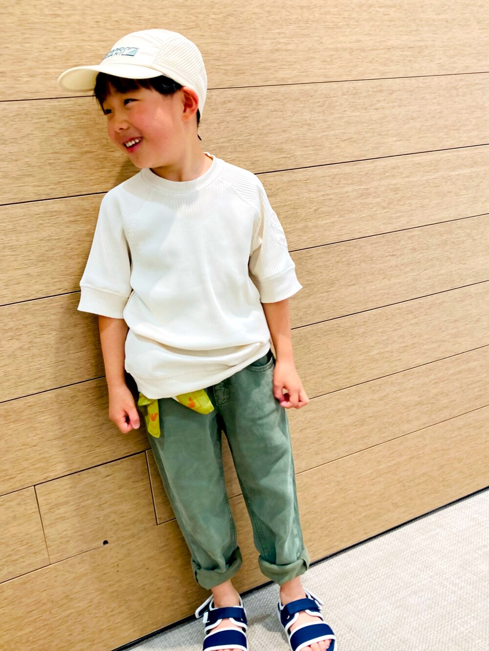 ベージュ系のTシャツ/カットソー、グリーン系のデニムパンツ、ブルー系のサンダルを着用したキッズの春コーディネートの4枚目の写真