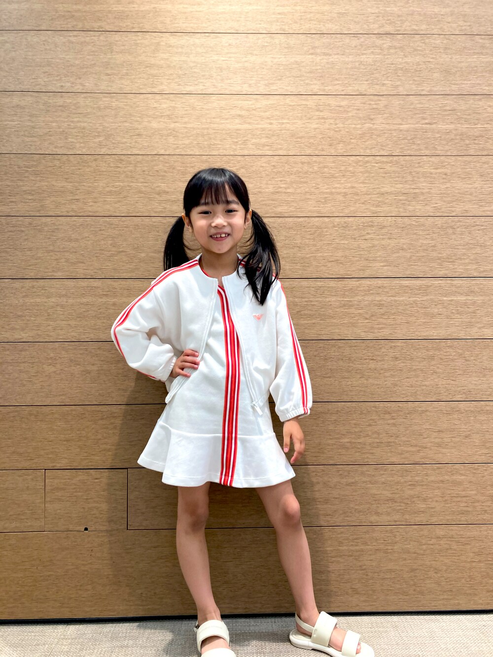 ホワイト系のサンダル、ホワイト系のジャケット/アウター、ホワイト系のワンピースを着用したキッズの春コーディネートの2枚目の写真
