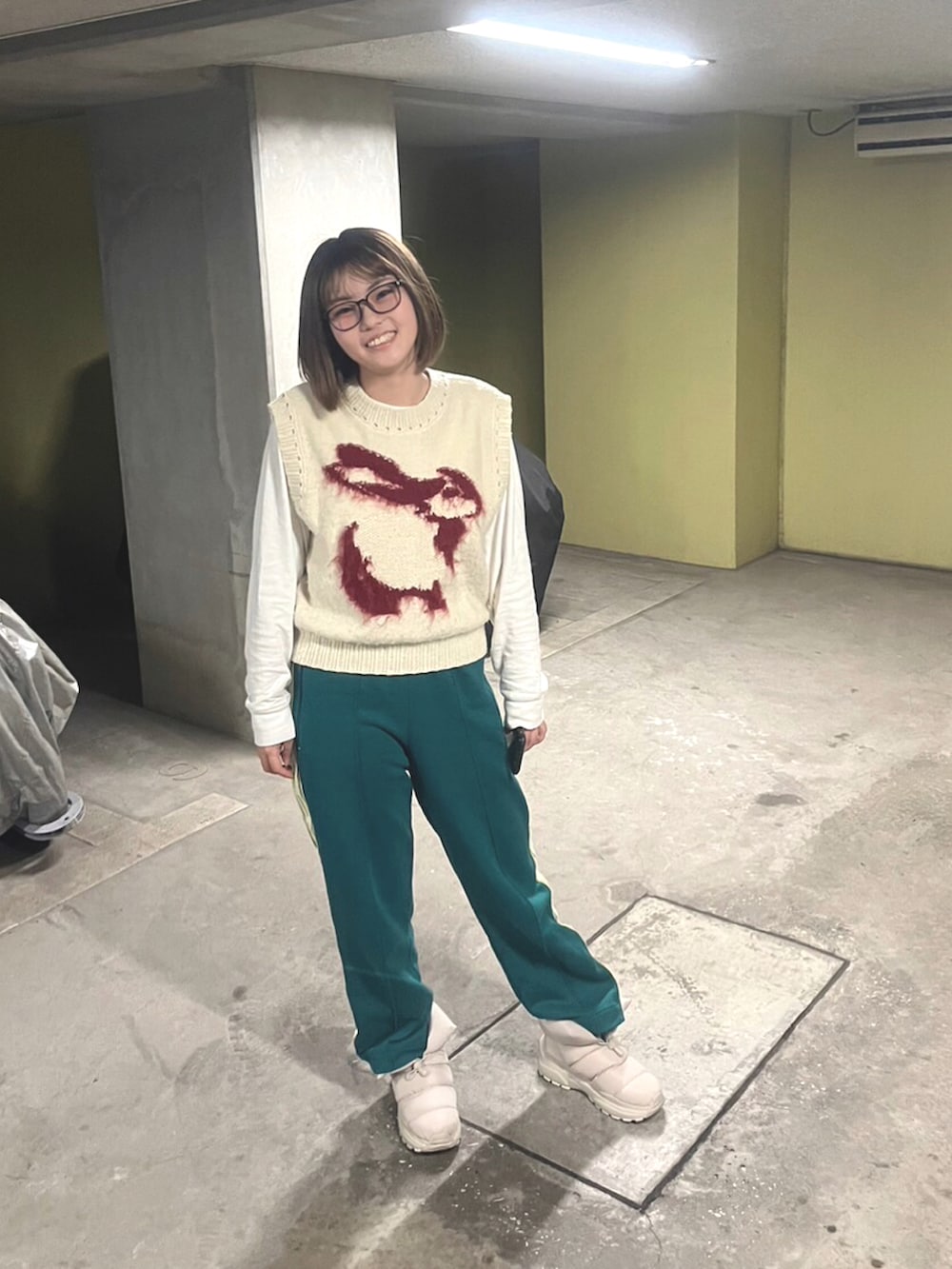 ホワイト系のニット/セーター、グリーン系のスウェットパンツ、ホワイト系のブーツを着用したレディースの春コーディネートの2枚目の写真