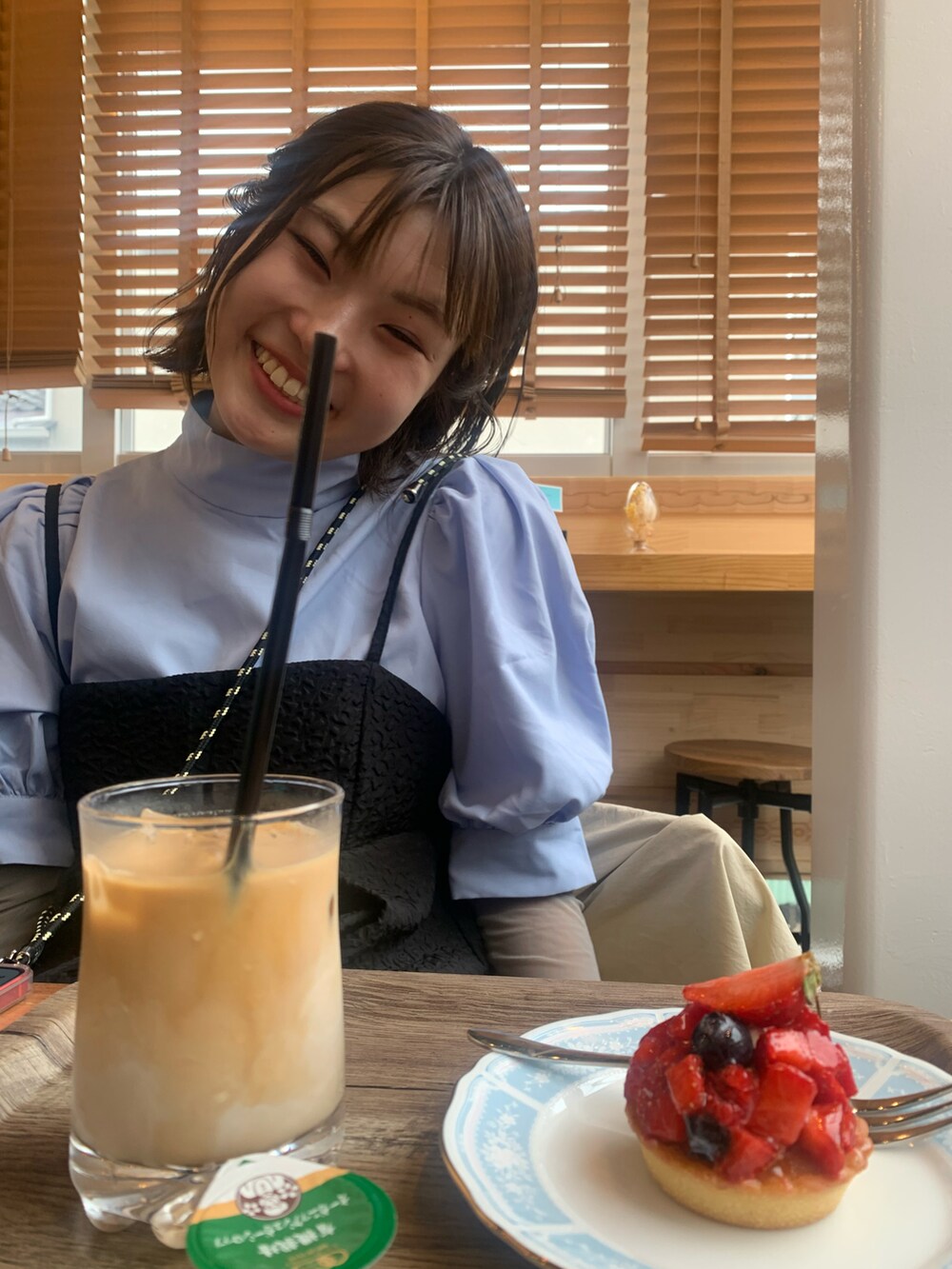 ベージュ系のブルゾン、ブルー系のスニーカー、ブラック系のワンピースを着用したレディースの春コーディネートの2枚目の写真