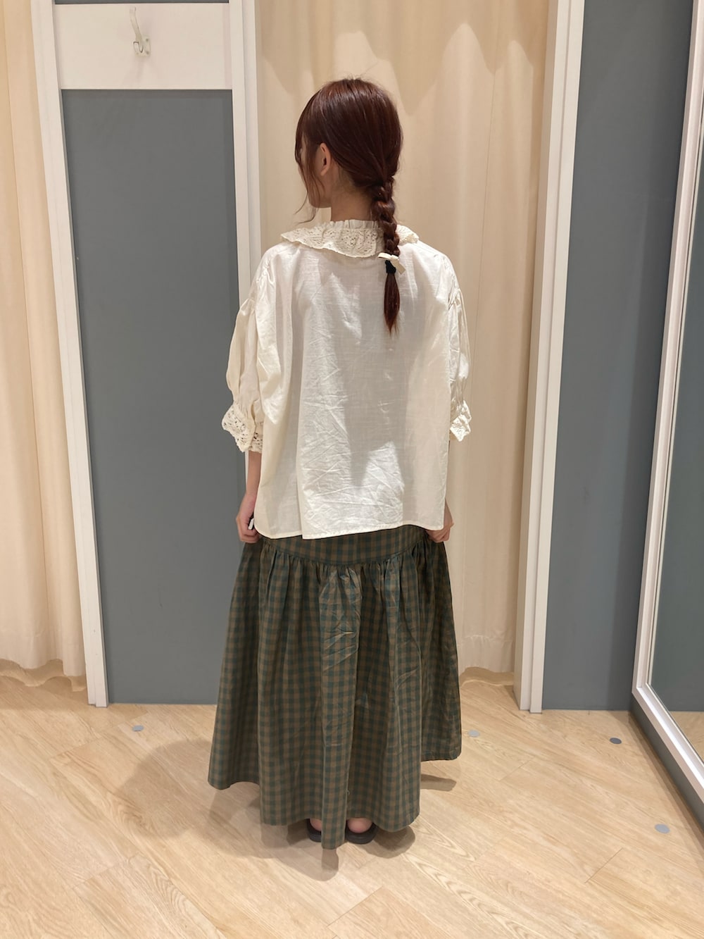 グリーン系のスカート、ホワイト系のシャツ/ブラウス、ブラウン系のサンダルを着用したレディースの夏コーディネートの2枚目の写真