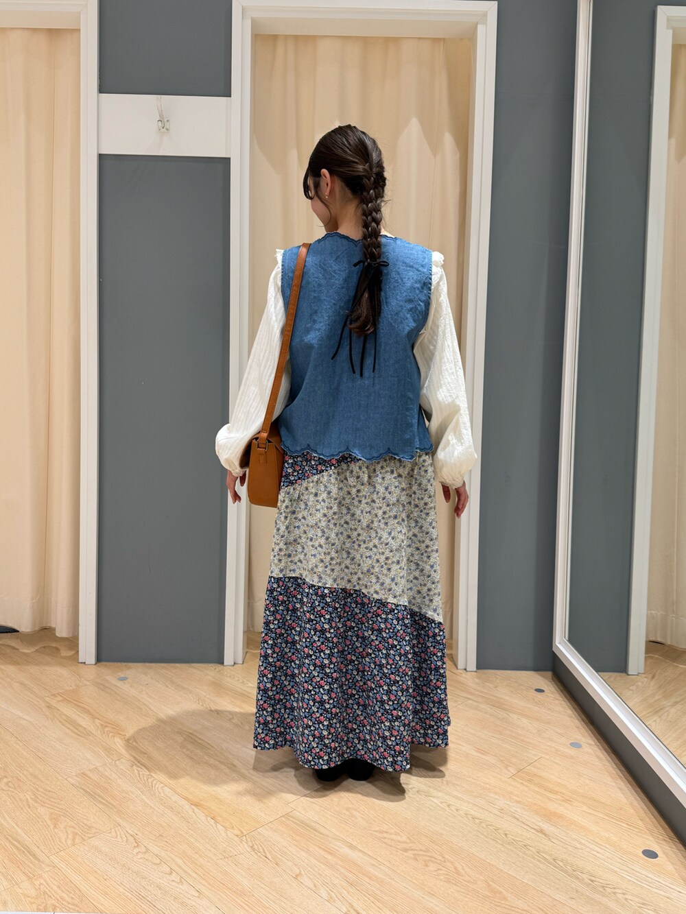 ブルー系のスカート、ホワイト系のシャツ/ブラウス、ブラウン系のハンドバッグを着用したレディースの春コーディネートの3枚目の写真