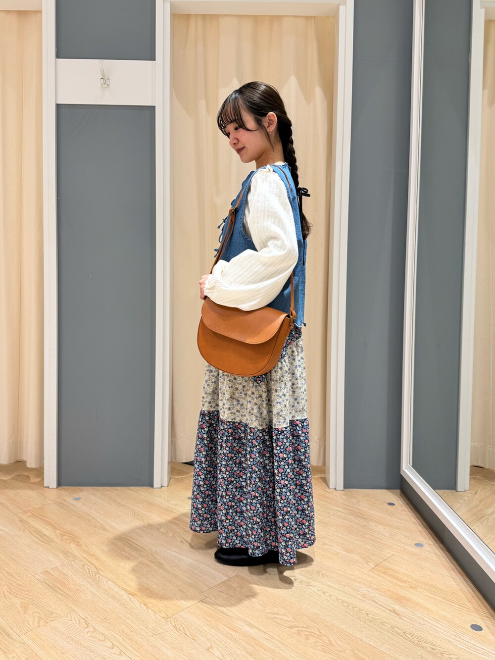 ブルー系のスカート、ホワイト系のシャツ/ブラウス、ブラウン系のハンドバッグを着用したレディースの春コーディネートの4枚目の写真