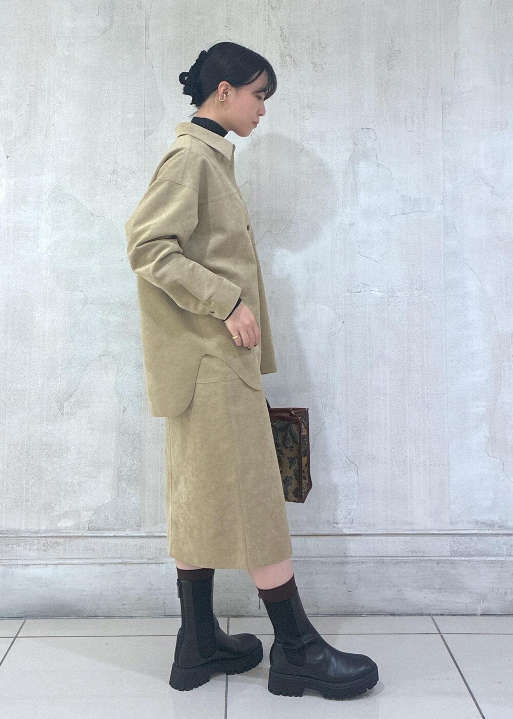 ベージュ系のシャツ/ブラウス、ベージュ系のスカート、ブラック系のニット/セーターを着用したレディースの秋コーディネートの5枚目の写真