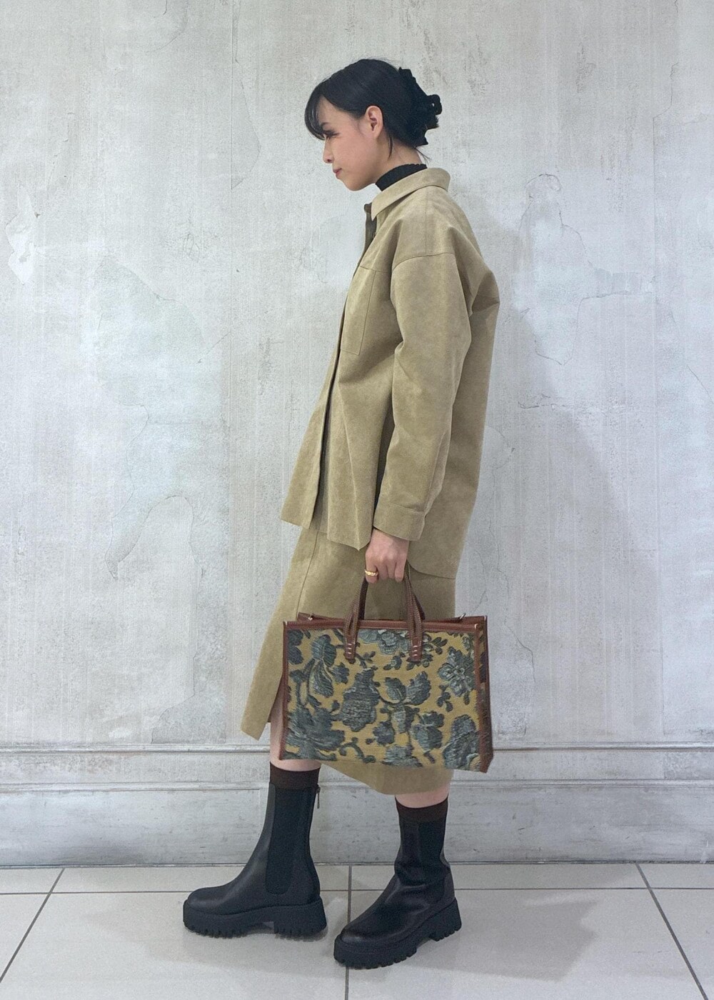 ベージュ系のシャツ/ブラウス、ベージュ系のスカート、ブラック系のニット/セーターを着用したレディースの秋コーディネートの3枚目の写真