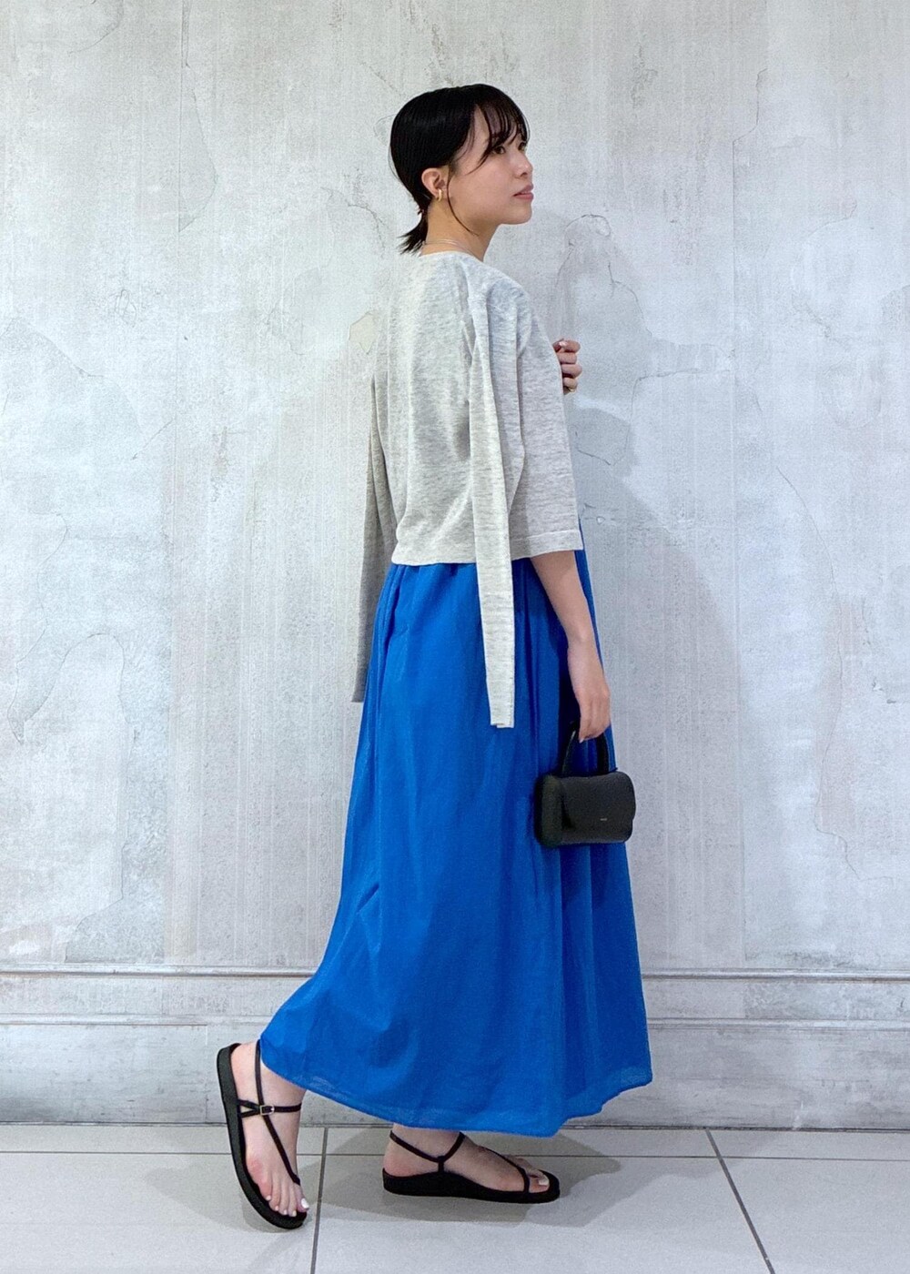 グレー系のカーディガン/ボレロ、ブラック系のサンダルを着用したレディースの春コーディネートの5枚目の写真