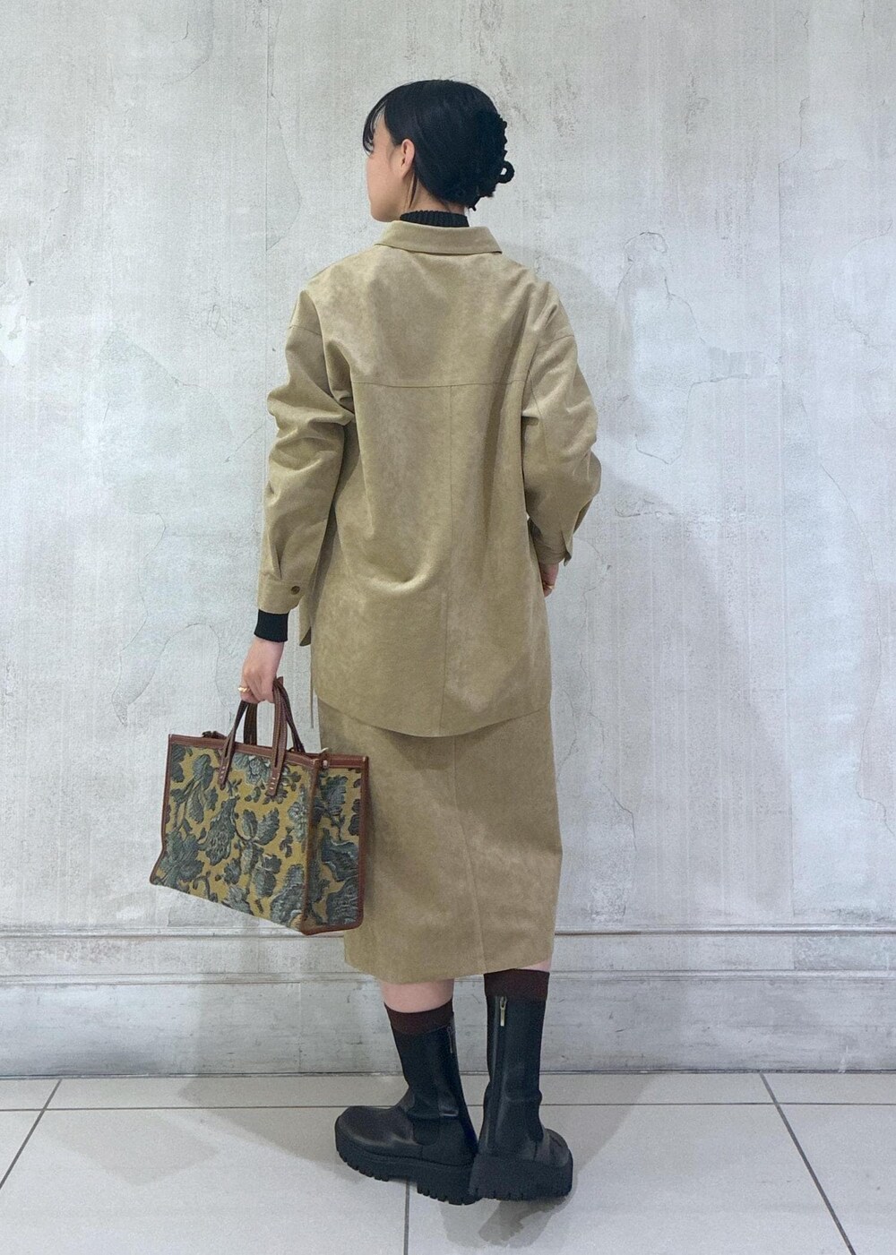 ベージュ系のシャツ/ブラウス、ベージュ系のスカート、ブラック系のニット/セーターを着用したレディースの秋コーディネートの4枚目の写真