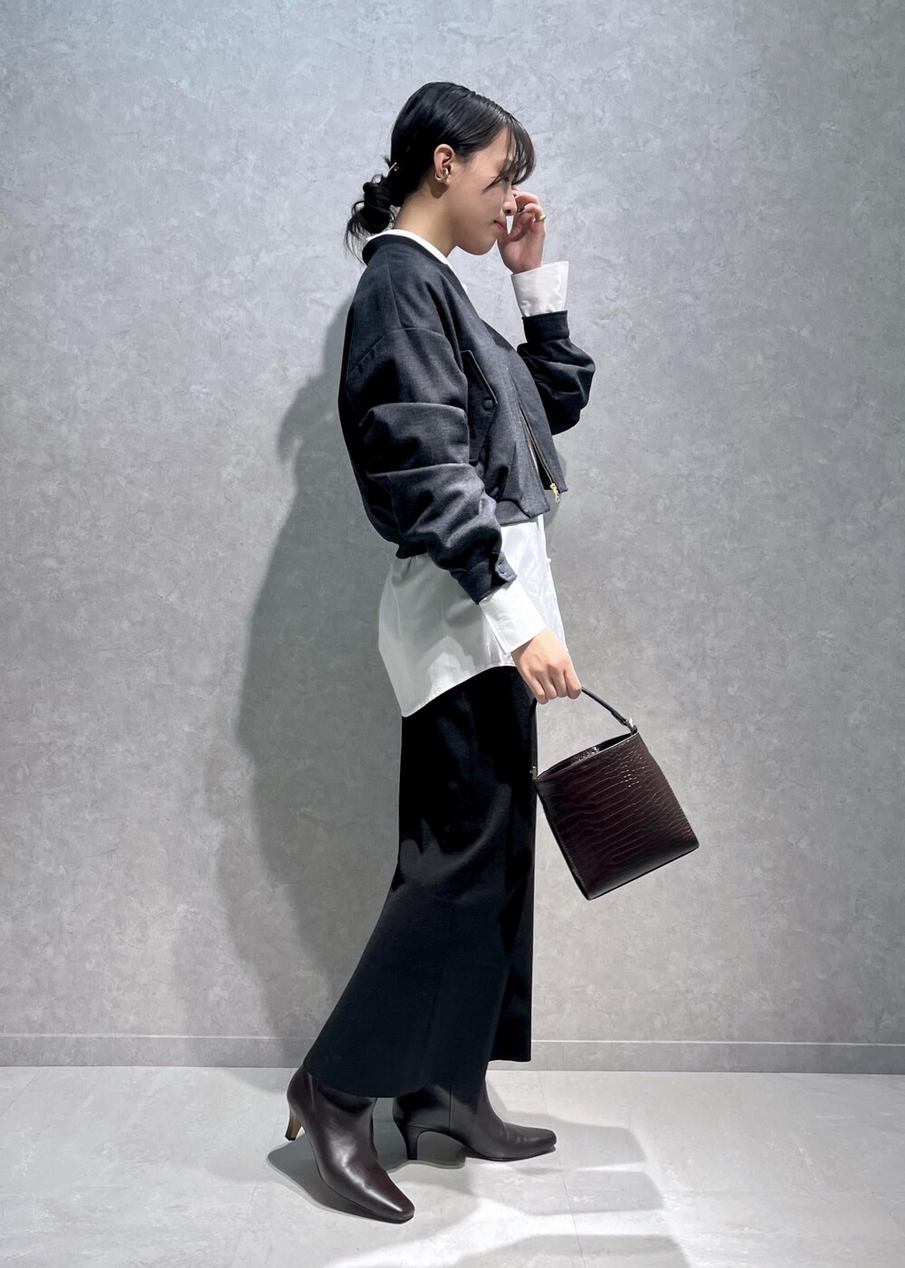 ブラウン系のブーツ、ホワイト系のシャツ/ブラウス、ブラウン系のショルダーバッグを着用したレディースの冬コーディネートの2枚目の写真