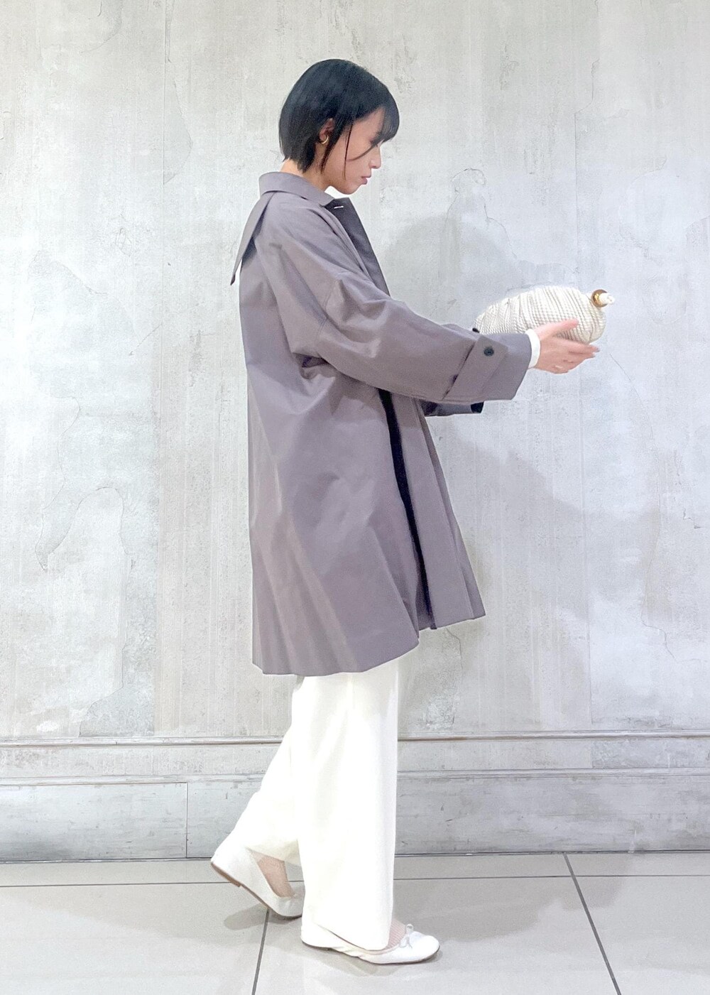 ホワイト系のその他パンツ、ホワイト系のカーディガン/ボレロ、グレー系のステンカラーコートを着用したレディースの冬コーディネートの4枚目の写真