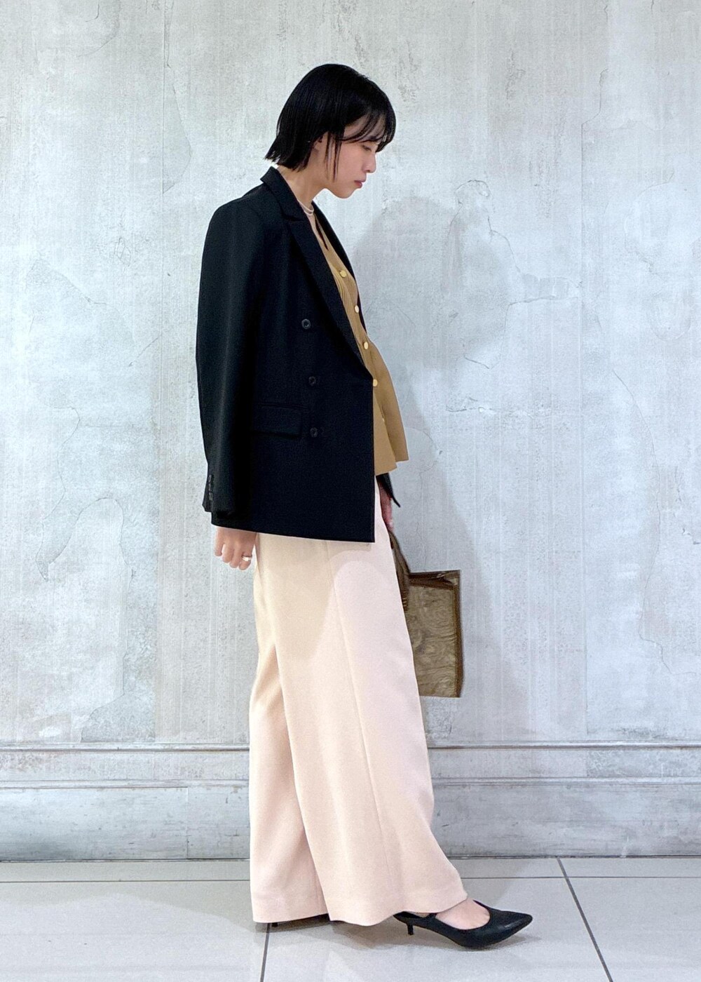 ブラック系のテーラードジャケット、ブラック系のタンクトップ、ピンク系のその他パンツを着用したレディースの春コーディネートの4枚目の写真