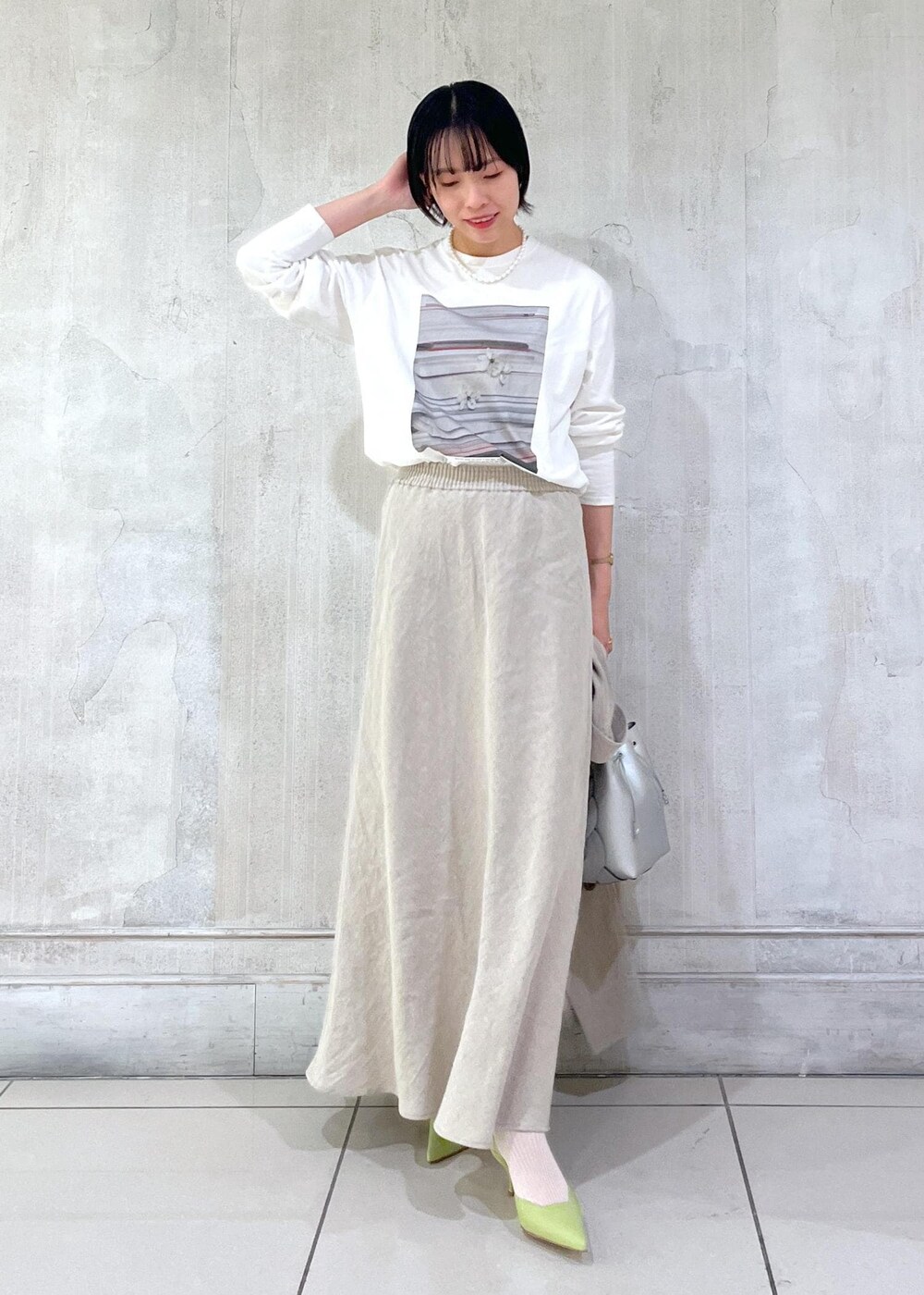 ベージュ系のテーラードジャケット、ベージュ系のスカート、ホワイト系のTシャツ/カットソーを着用したレディースの冬コーディネートの5枚目の写真