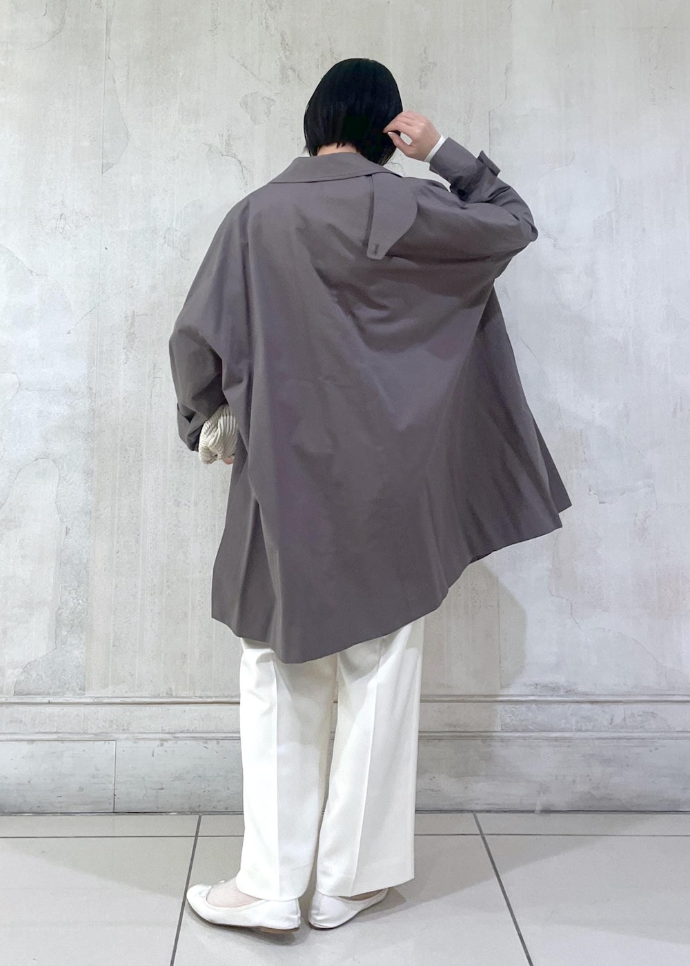 ホワイト系のその他パンツ、ホワイト系のカーディガン/ボレロ、グレー系のステンカラーコートを着用したレディースの冬コーディネートの3枚目の写真