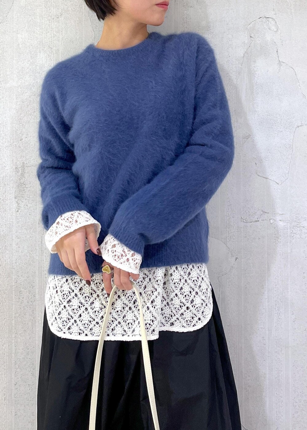 ホワイト系のショルダーバッグ、ブラック系のスカート、ホワイト系のTシャツ/カットソーを着用したレディースの冬コーディネートの5枚目の写真