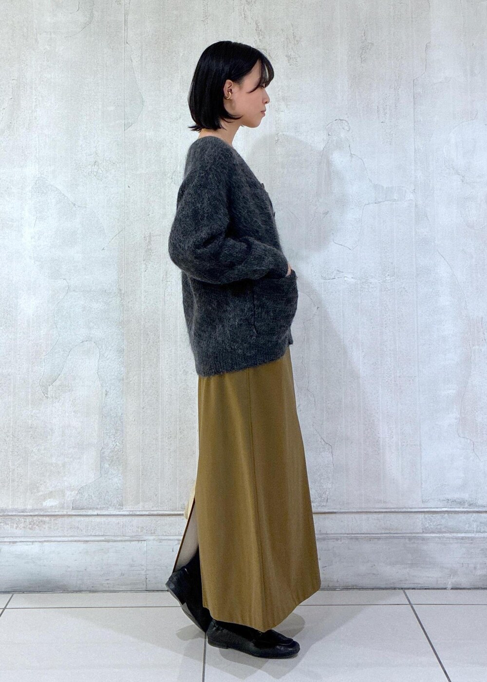 グレー系のカーディガン/ボレロ、ブラウン系のワンピース、ベージュ系のショルダーバッグを着用したレディースの冬コーディネートの5枚目の写真