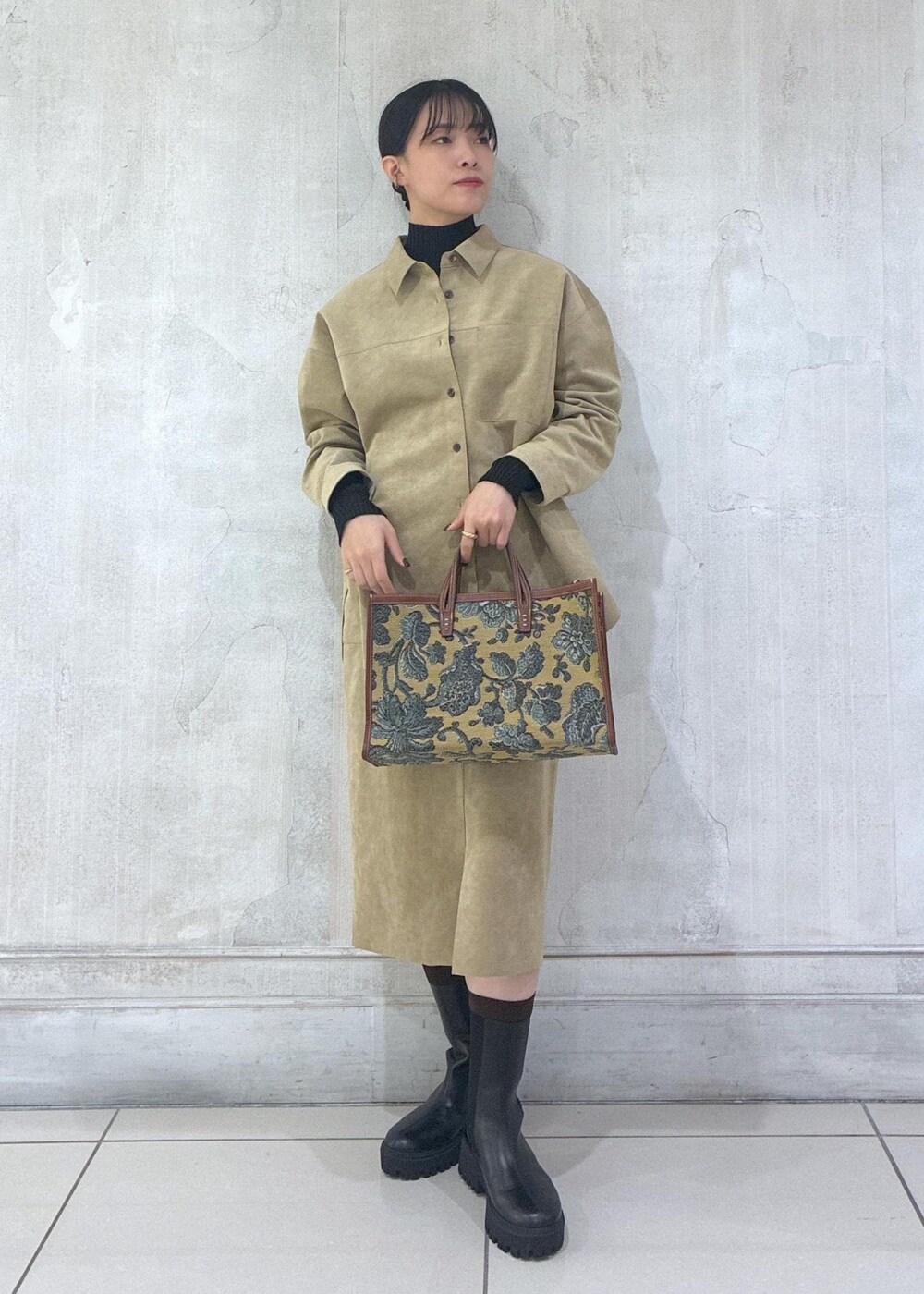 ベージュ系のシャツ/ブラウス、ベージュ系のスカート、ブラック系のニット/セーターを着用したレディースの秋コーディネートの2枚目の写真