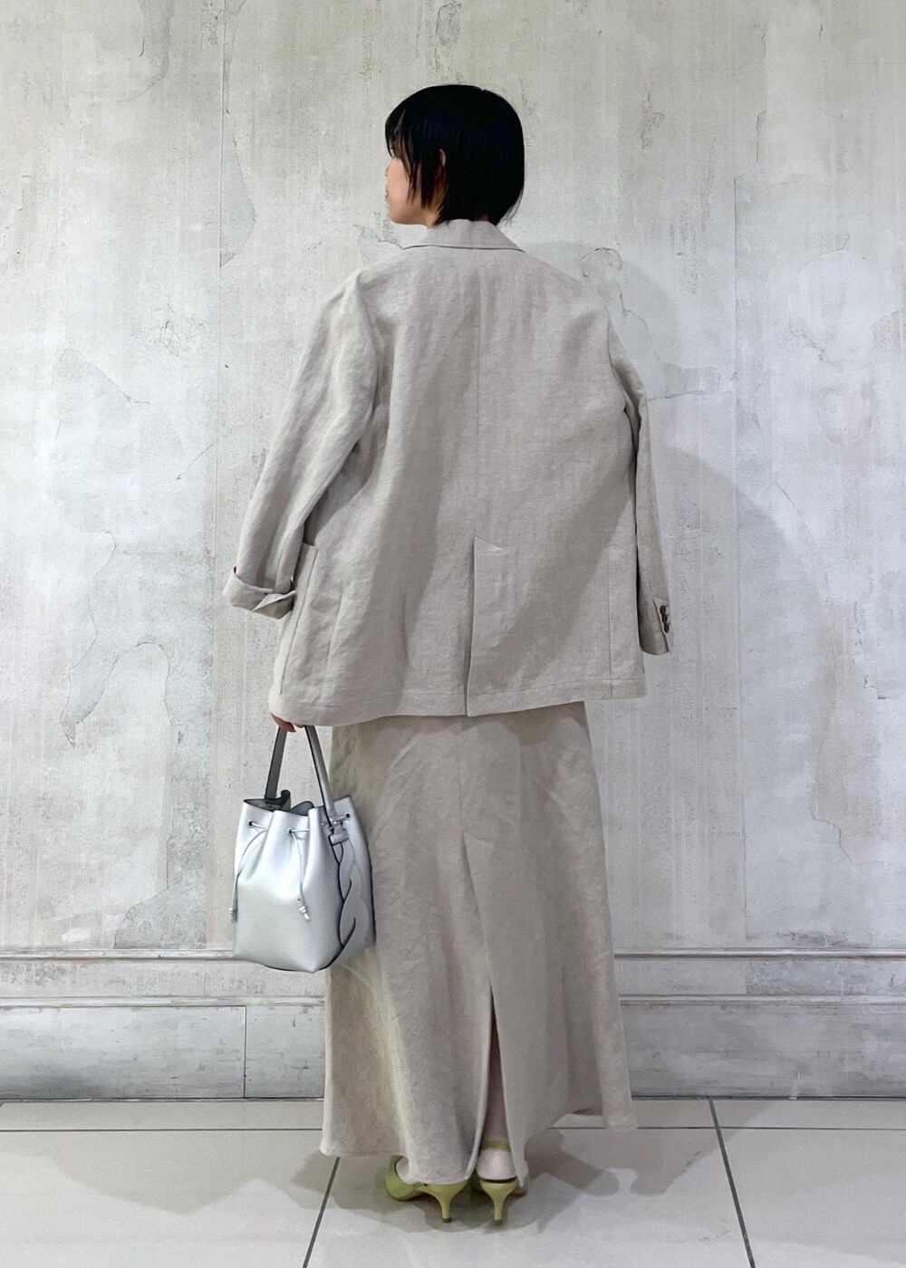 ベージュ系のテーラードジャケット、ベージュ系のスカート、ホワイト系のTシャツ/カットソーを着用したレディースの冬コーディネートの3枚目の写真