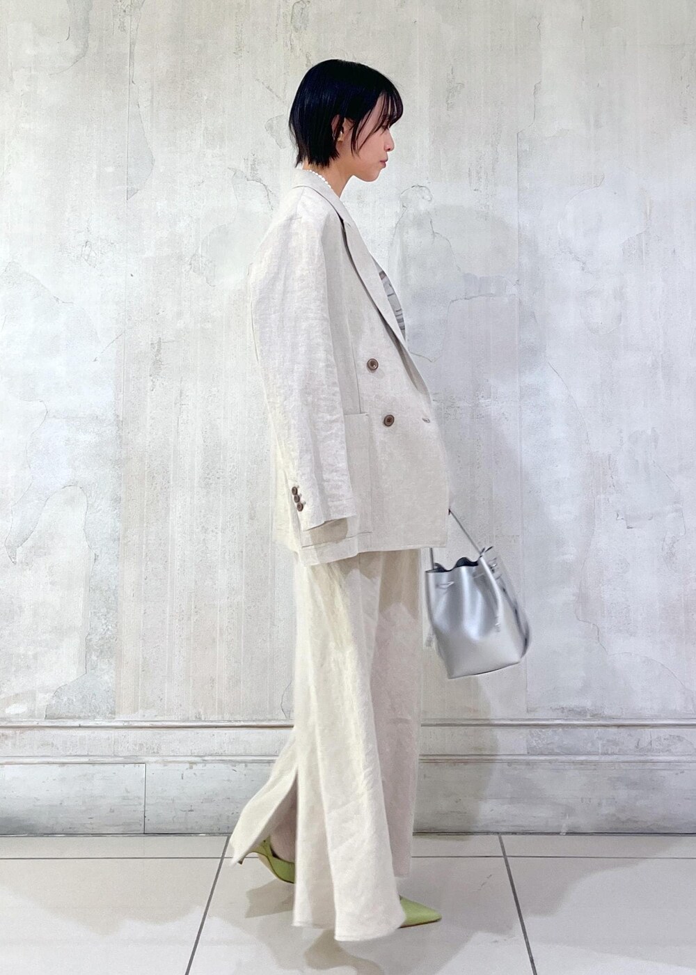 ベージュ系のテーラードジャケット、ベージュ系のスカート、ホワイト系のTシャツ/カットソーを着用したレディースの冬コーディネートの2枚目の写真