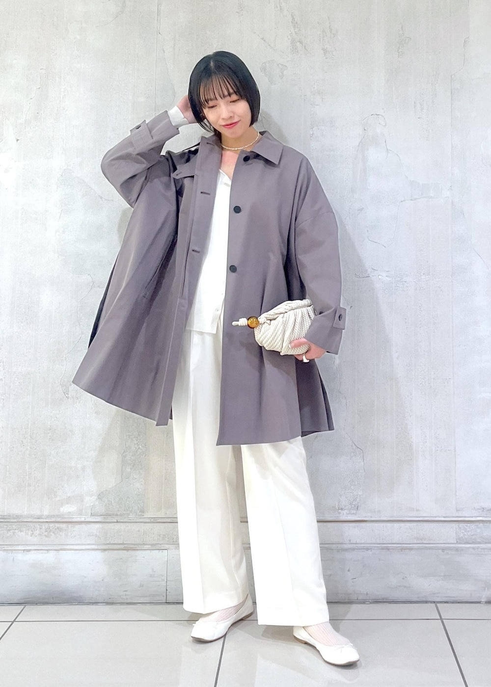 ホワイト系のその他パンツ、ホワイト系のカーディガン/ボレロ、グレー系のステンカラーコートを着用したレディースの冬コーディネートの5枚目の写真