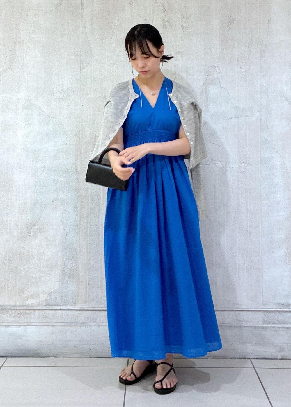 グレー系のカーディガン/ボレロ、ブラック系のサンダルを着用したレディースの春コーディネートの4枚目の写真