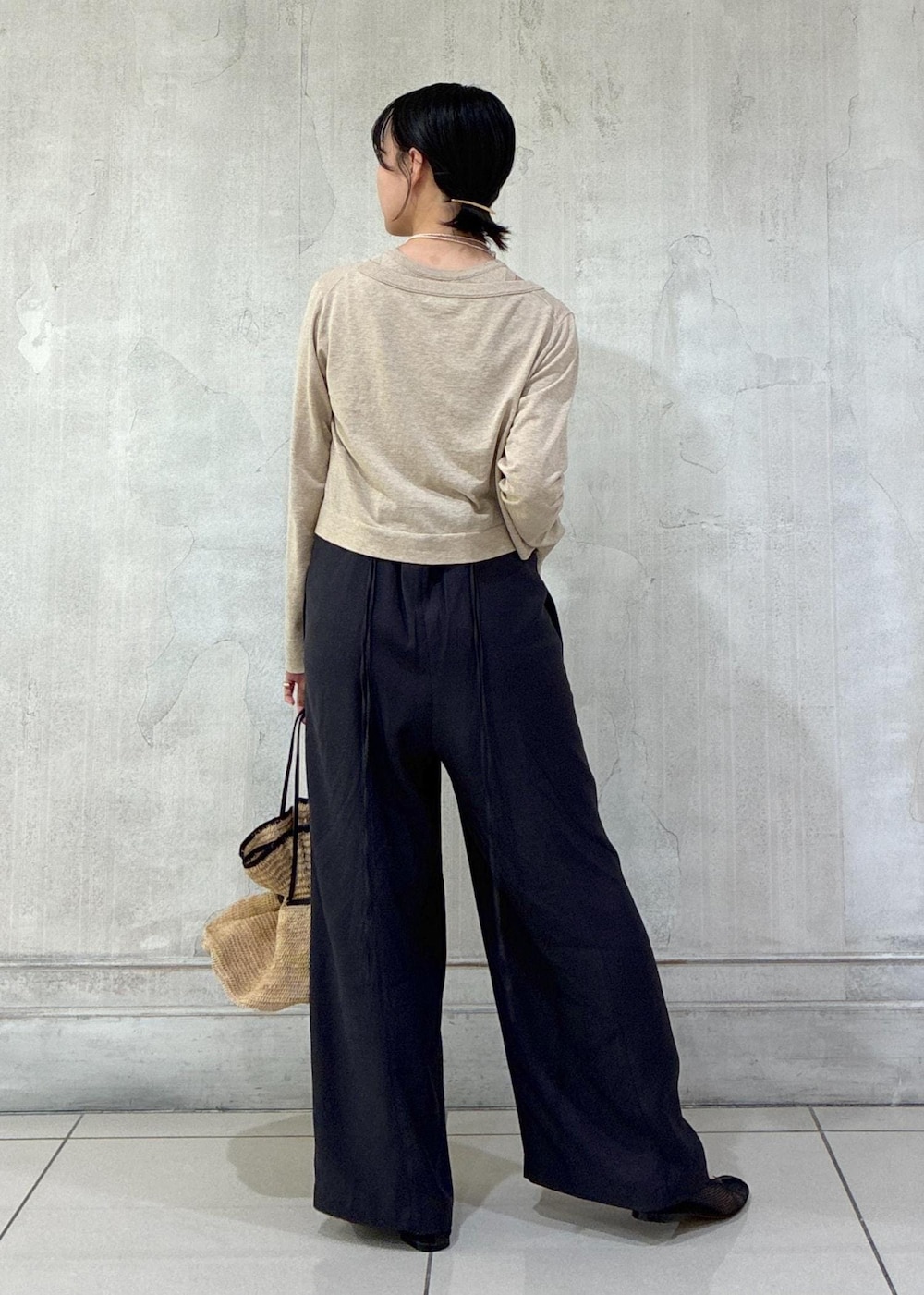 ブラック系のパンプス、ベージュ系のカーディガン/ボレロ、ベージュ系のタンクトップを着用したレディースの春コーディネートの4枚目の写真