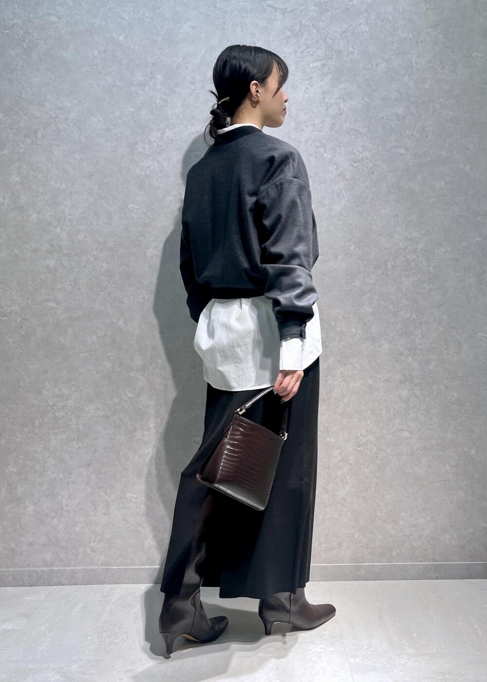 ブラウン系のブーツ、ホワイト系のシャツ/ブラウス、ブラウン系のショルダーバッグを着用したレディースの冬コーディネートの3枚目の写真