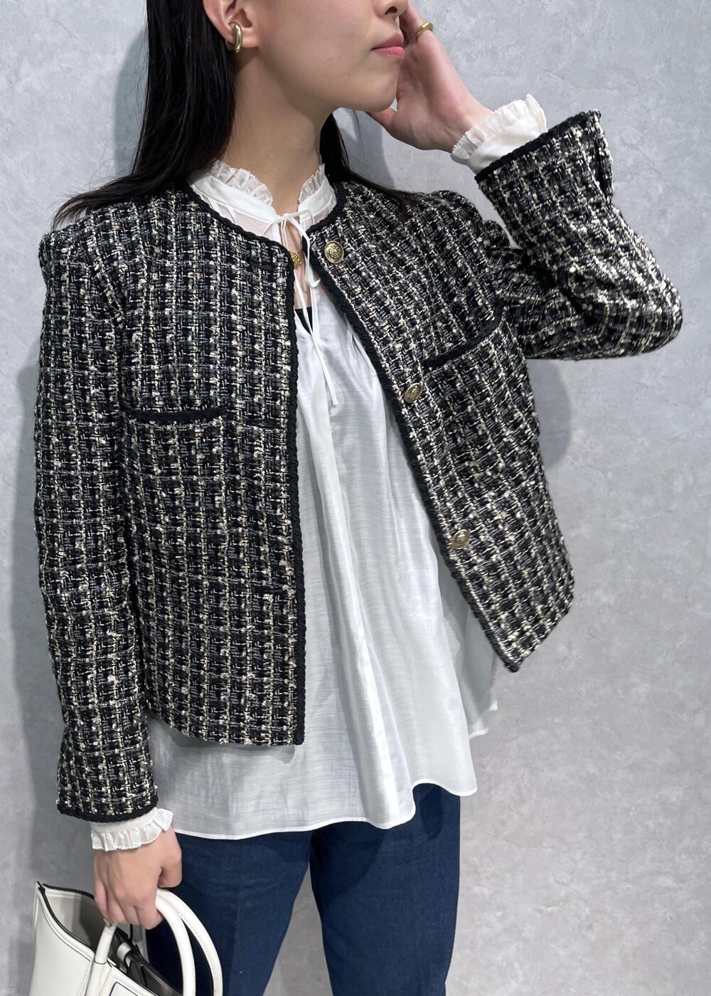 ブラック系のパンプス、ホワイト系のトートバッグ、ブルー系のデニムパンツを着用したレディースの秋コーディネートの5枚目の写真