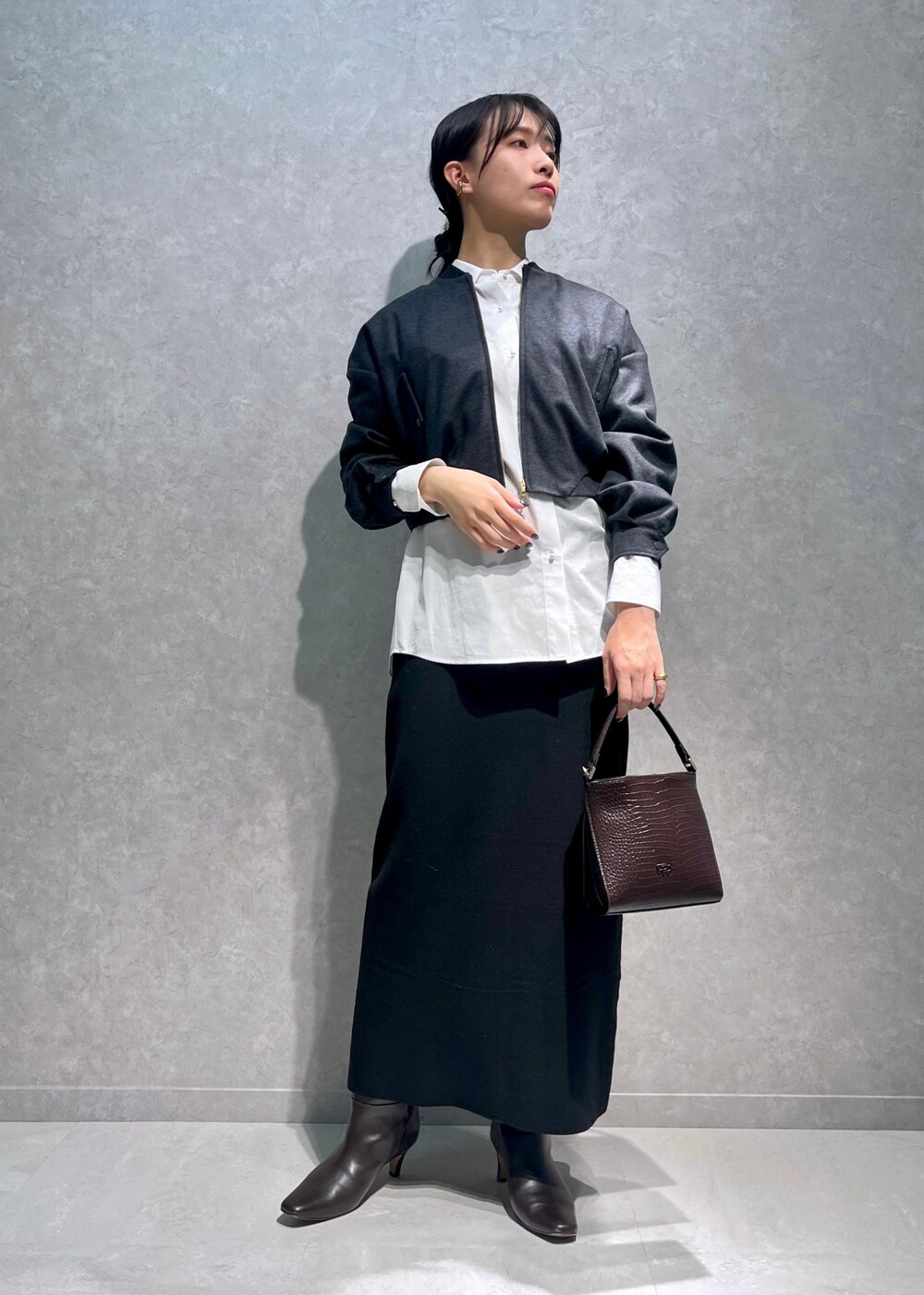 ブラウン系のブーツ、ホワイト系のシャツ/ブラウス、ブラウン系のショルダーバッグを着用したレディースの冬コーディネートの4枚目の写真