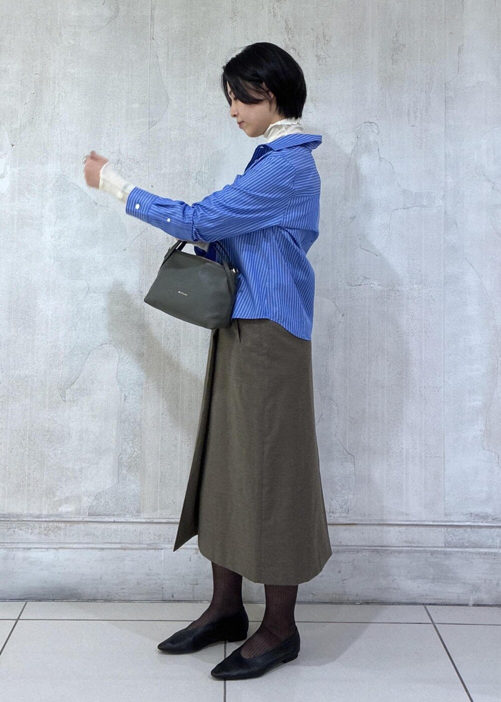 ブラック系のパンプス、ブルー系のシャツ/ブラウス、ブラウン系のソックス/靴下を着用したレディースの秋コーディネートの3枚目の写真