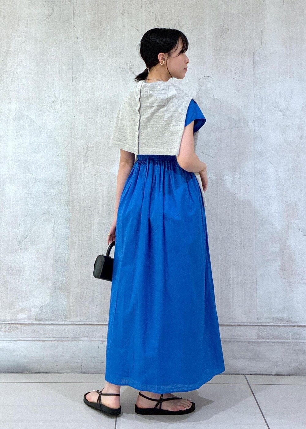 グレー系のカーディガン/ボレロ、ブラック系のサンダルを着用したレディースの春コーディネートの3枚目の写真