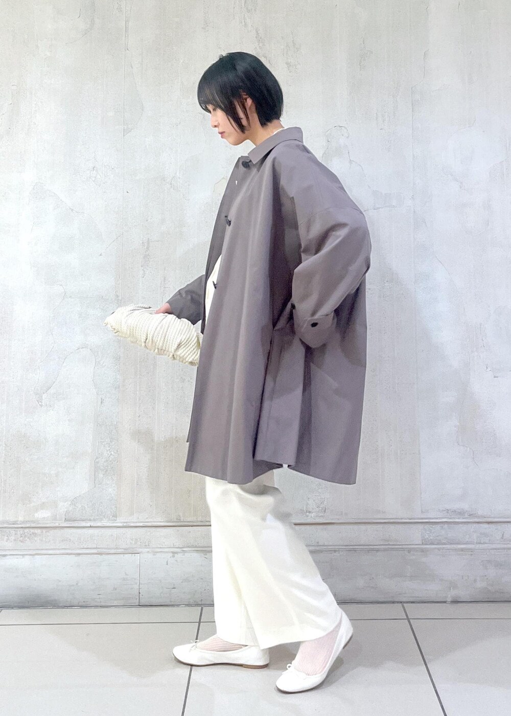 ホワイト系のその他パンツ、ホワイト系のカーディガン/ボレロ、グレー系のステンカラーコートを着用したレディースの冬コーディネートの2枚目の写真