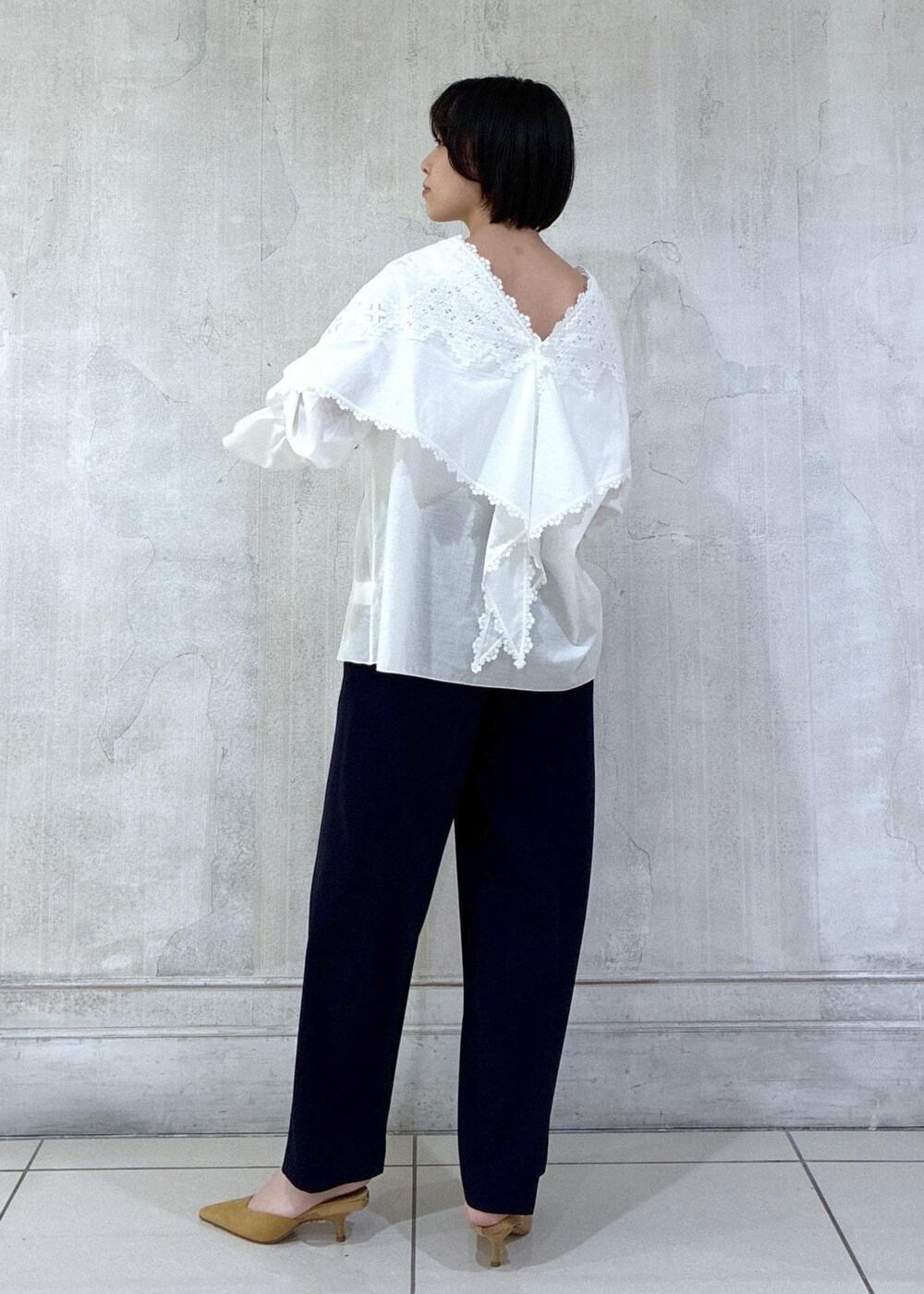 ベージュ系のショルダーバッグ、ホワイト系のシャツ/ブラウス、ブルー系のスラックスを着用したレディースの冬コーディネートの5枚目の写真