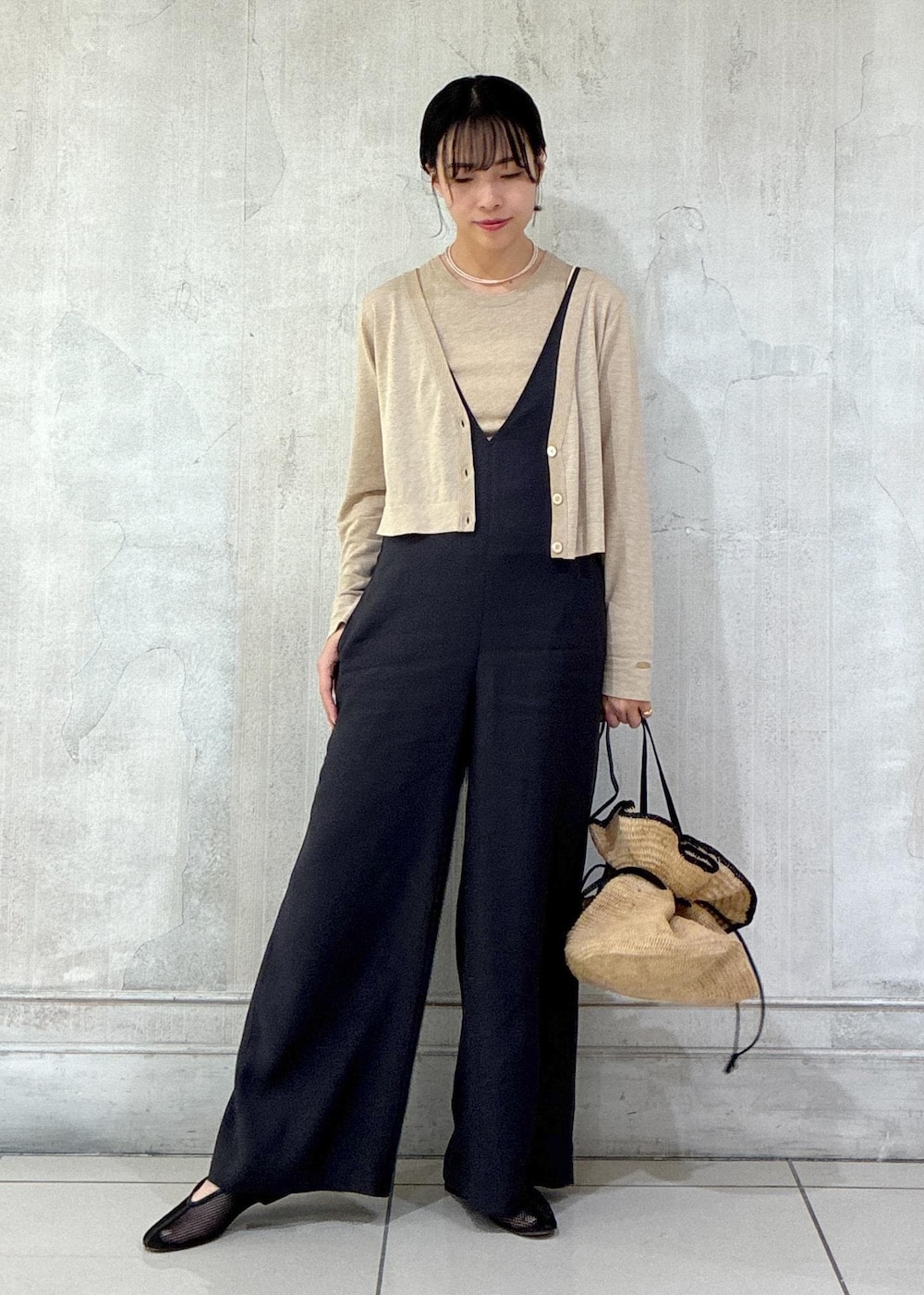 ブラック系のパンプス、ベージュ系のカーディガン/ボレロ、ベージュ系のタンクトップを着用したレディースの春コーディネートの2枚目の写真