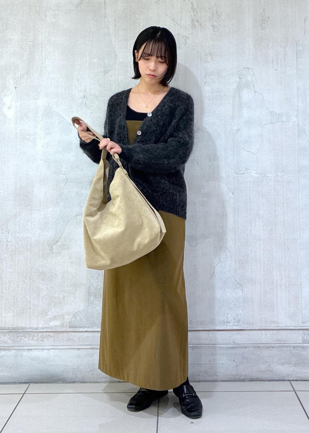 グレー系のカーディガン/ボレロ、ブラウン系のワンピース、ベージュ系のショルダーバッグを着用したレディースの冬コーディネートの6枚目の写真