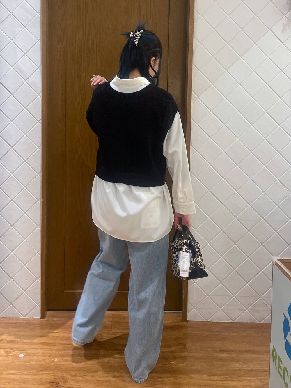 ブルー系のデニムパンツ、その他のショルダーバッグ、ブラック系のベストを着用したレディースの春コーディネートの3枚目の写真