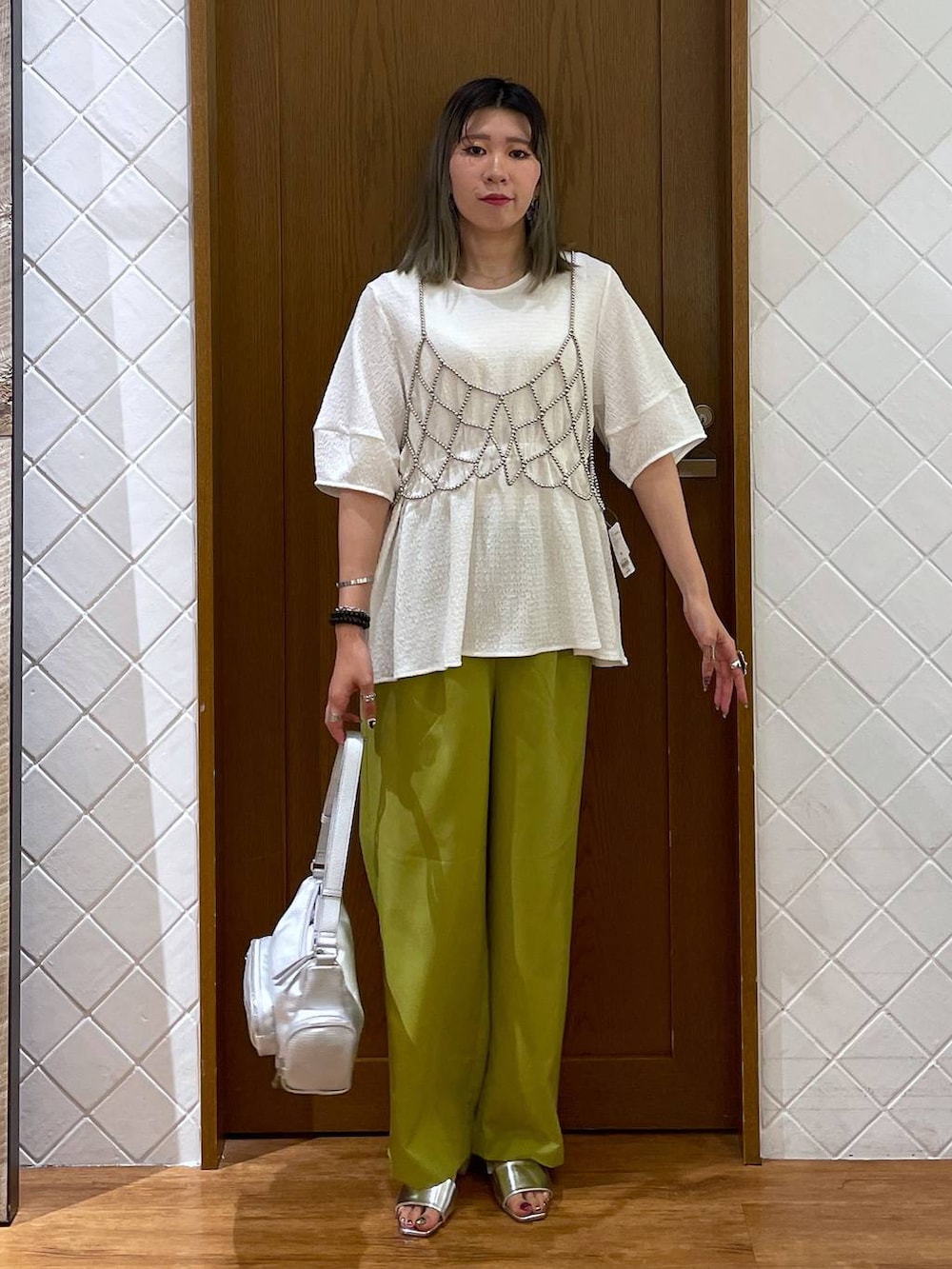 シルバー系のショルダーバッグ、シルバー系のサンダル、イエロー系のその他パンツを着用したレディースの夏コーディネートの2枚目の写真