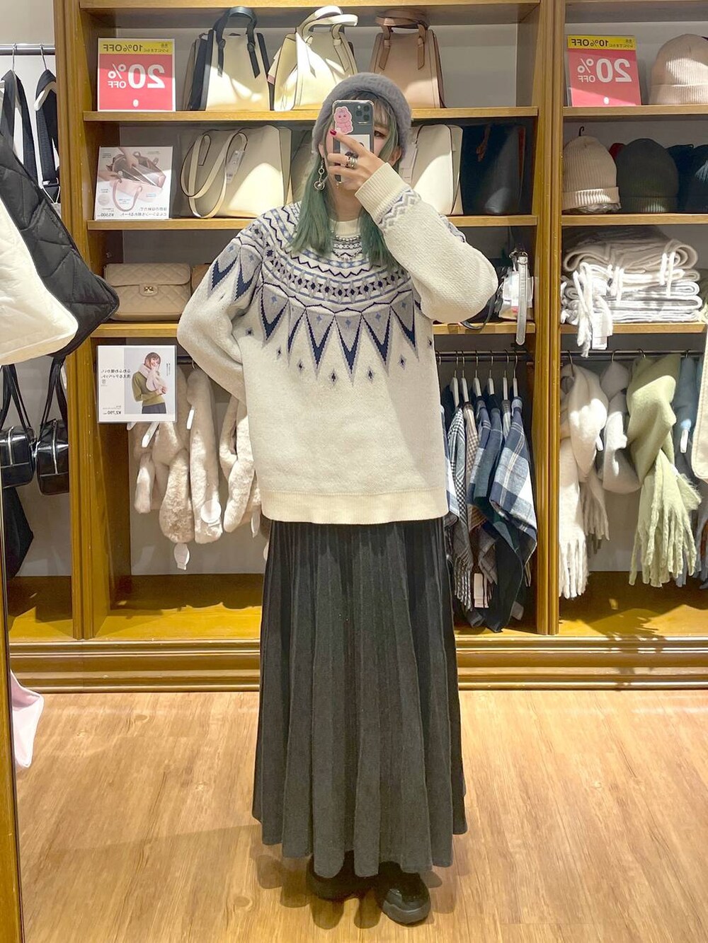 ホワイト系のニット/セーター、ブラック系のブーツ、グレー系のスカートを着用したレディースの冬コーディネートの2枚目の写真