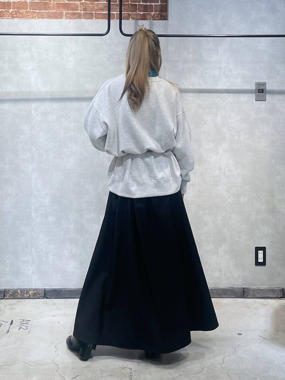 ブルー系のニット/セーター、ブラック系のブーツ、ブラック系のスカートを着用したレディースの冬コーディネートの3枚目の写真