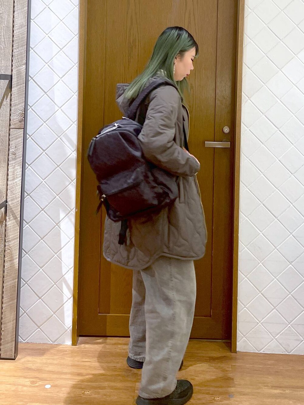 グリーン系のその他アウター、グレー系のデニムパンツ、ブラック系のブーツを着用したレディースの冬コーディネートの2枚目の写真