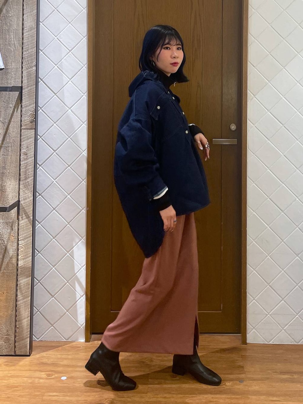 ブルー系のシャツ/ブラウス、ブラック系のブーツ、ピンク系のスカートを着用したレディースの春コーディネートの3枚目の写真