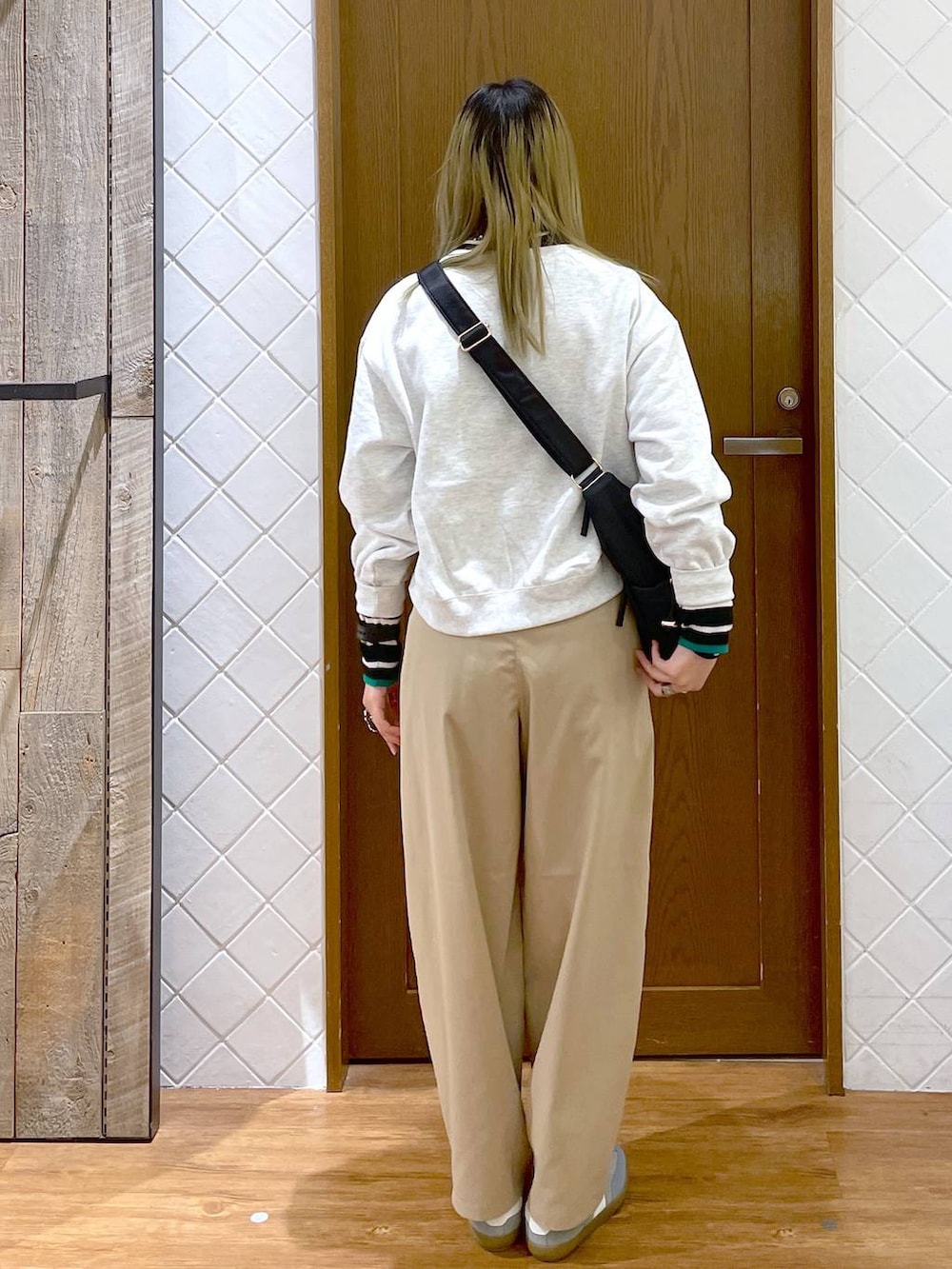 ブラック系のショルダーバッグ、ブラック系のニット/セーター、ベージュ系のその他パンツを着用したレディースの冬コーディネートの4枚目の写真