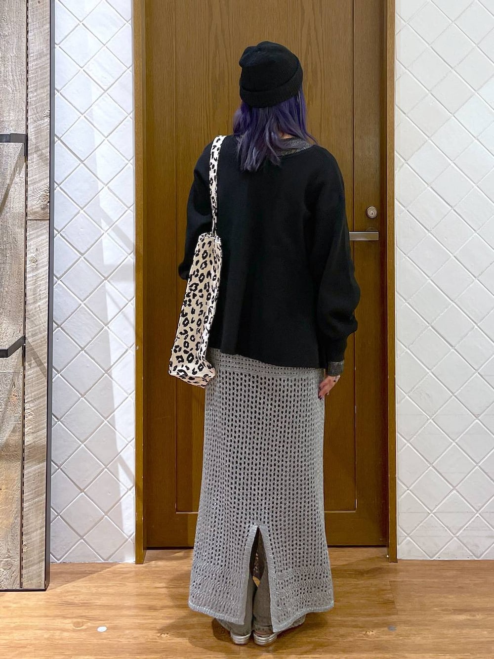 グレー系のデニムパンツ、ブラウン系のトートバッグ、シルバー系のパンプスを着用したレディースの秋コーディネートの4枚目の写真