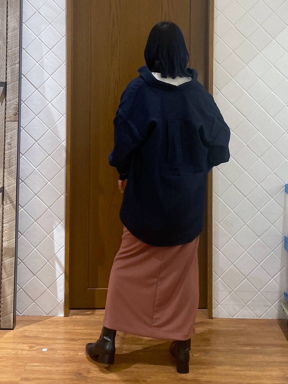 ブルー系のシャツ/ブラウス、ブラック系のブーツ、ピンク系のスカートを着用したレディースの春コーディネートの4枚目の写真