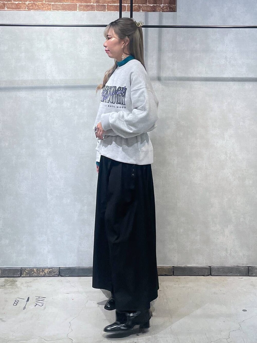 ブルー系のニット/セーター、ブラック系のブーツ、ブラック系のスカートを着用したレディースの冬コーディネートの2枚目の写真