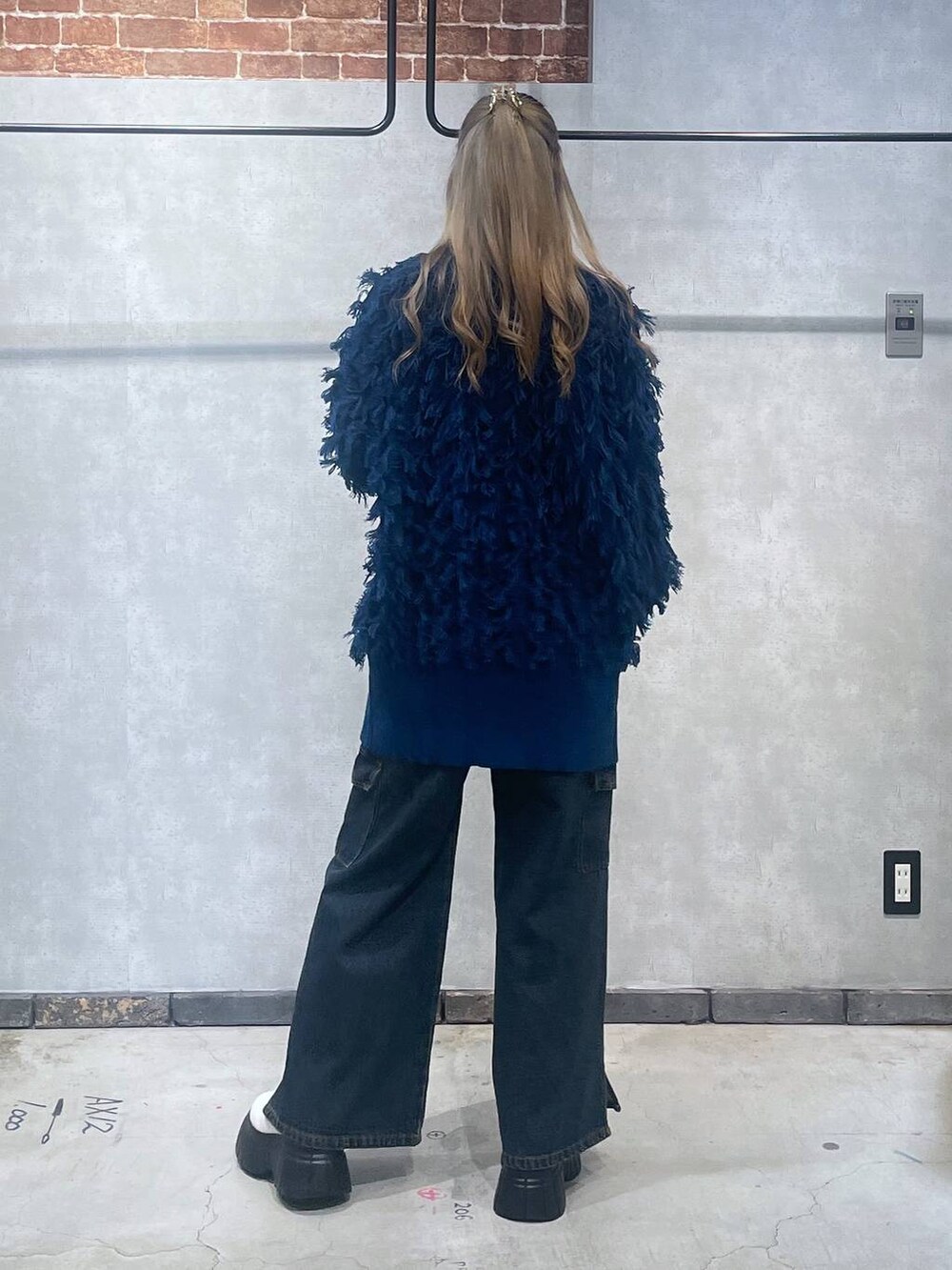 ホワイト系のブーツ、ブラック系のTシャツ/カットソー、ブルー系のニット/セーターを着用したレディースの冬コーディネートの3枚目の写真